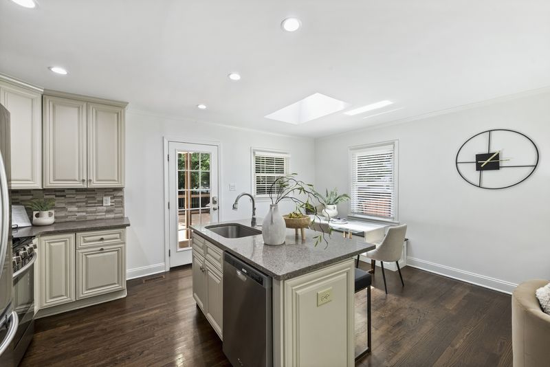Kitchen island with a sink and a glass door out to the deck