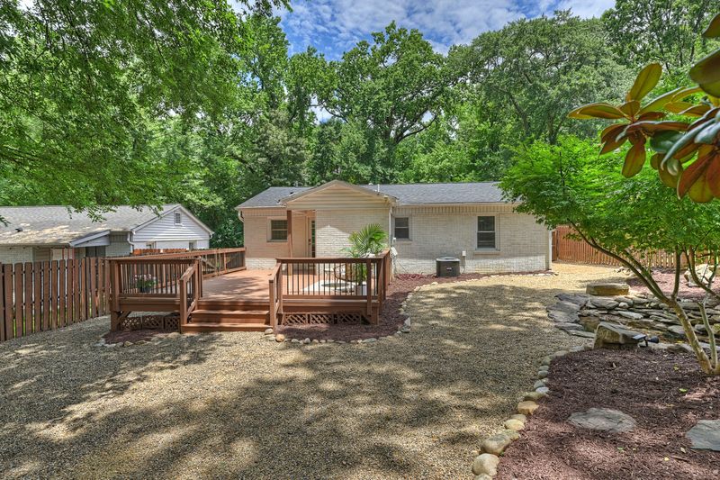 The back of the house, the deck, and the fenced yard