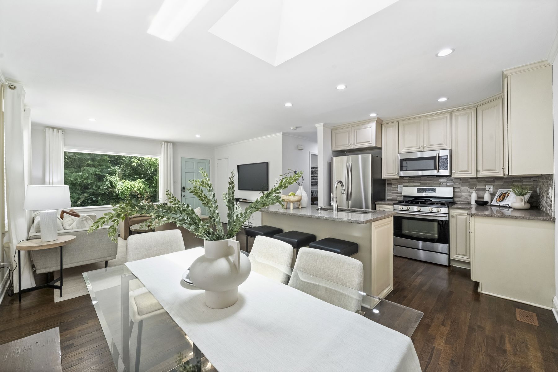 The open main level: living, dining, and kitchen in one sunlit room under a skylight