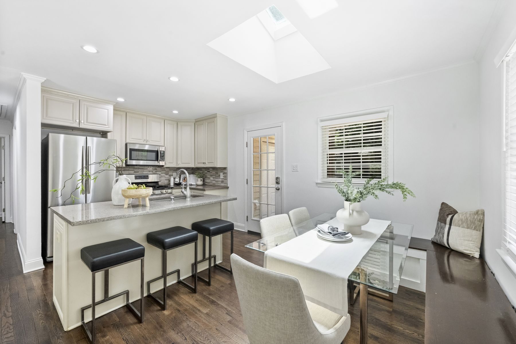 Kitchen with an island, stone counters, stainless appliances, and a built-in banquette